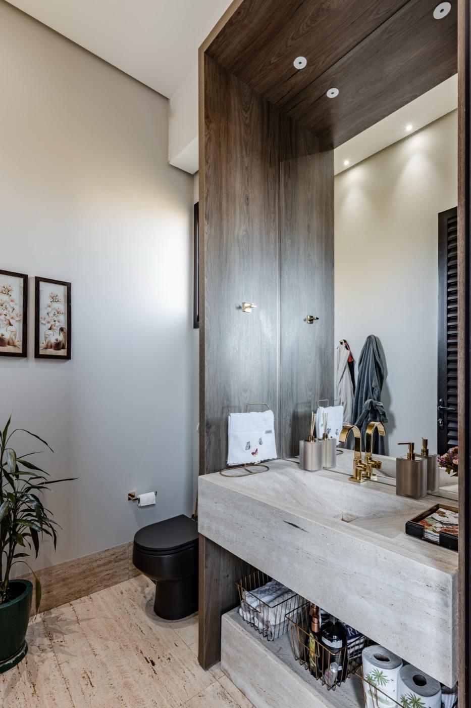 Lavabo com cuba esculpida e revestimento amadeirado de piso a teto.